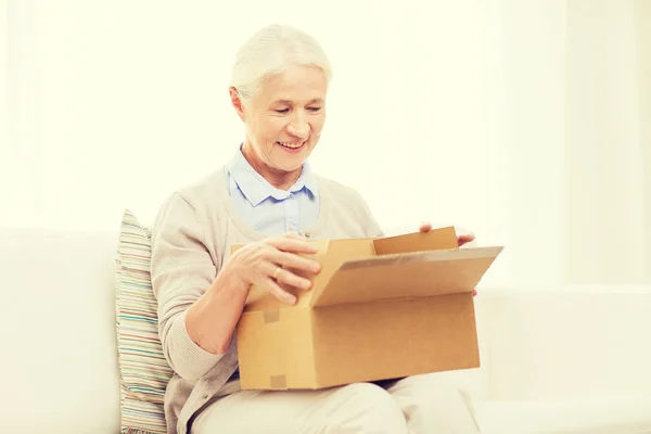 Mujer mayor feliz con caja de paquete en casa —  Fotos de Stock