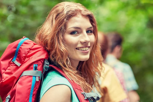 Gruppe lächelnder Freunde mit Rucksäcken beim Wandern lizenzfreie Stockbilder