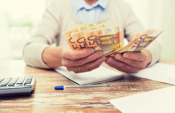 Nahaufnahme einer Seniorin, die zu Hause Geld zählt — Stockfoto