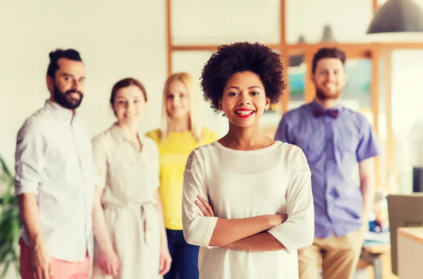 Feliz joven mujer sobre creativo equipo en la oficina — Foto de Stock