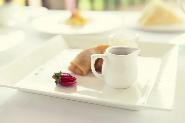 Närbild på pannkakor och honung eller sylt på plattan — Stockfoto