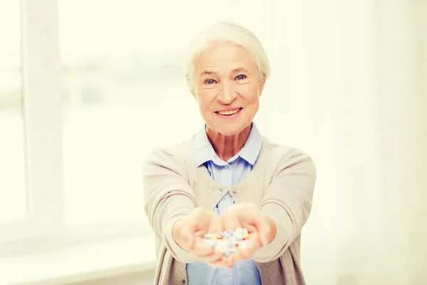 Счастливая пожилая женщина с медициной дома — стоковое фото