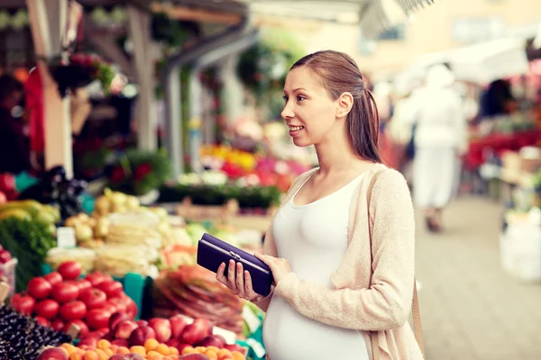 Schwangere mit Geldbörse kauft Lebensmittel auf Markt — Stockfoto