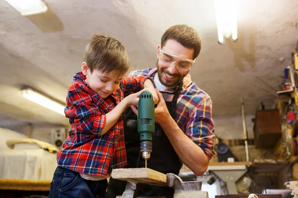 Father and son with drill working at workshop — Stock Photo, Image