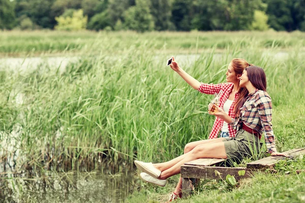 Happy women taking selfie by smartphone outdoors — Stock fotografie