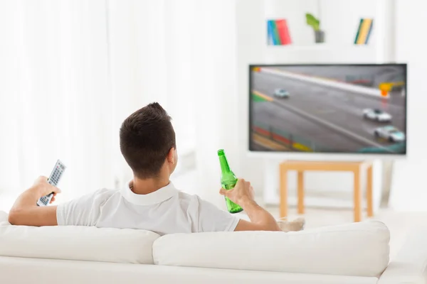 Homem assistindo tv e beber cerveja em casa — Fotografia de Stock