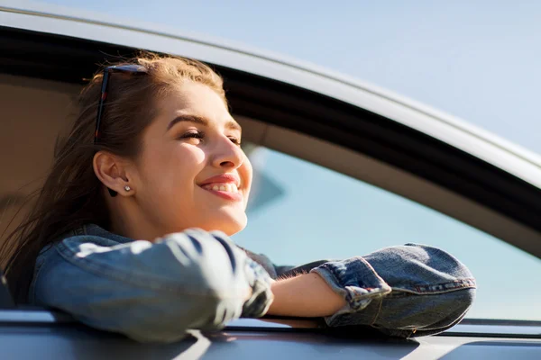 Šťastný dospívající dívka nebo mladá žena v autě — Stock fotografie