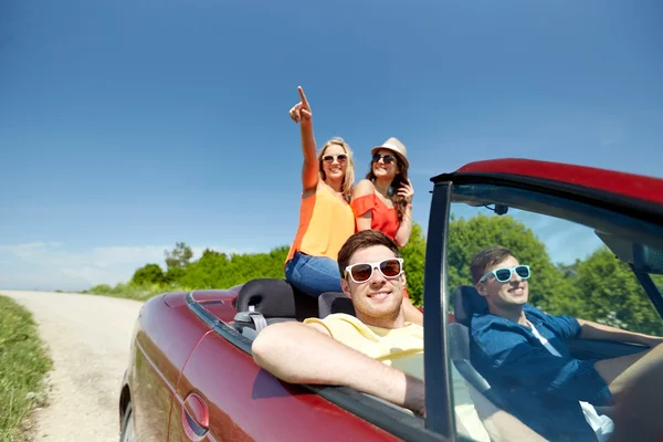 Amigos felices conduciendo en coche cabriolet en el país — Foto de Stock
