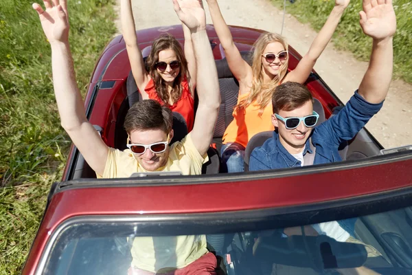 Happy vänner körning i cabriolet bil på landet — Stockfoto