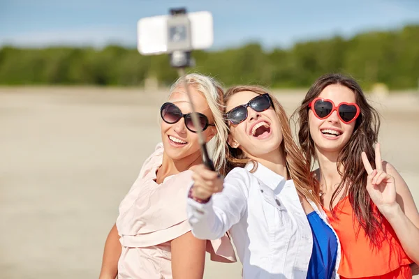 Grupa kobiet uśmiechający się biorąc selfie na plaży — Zdjęcie stockowe