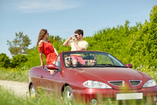 Amigos felices con la conducción de la cámara en coche cabriolet —  Fotos de Stock