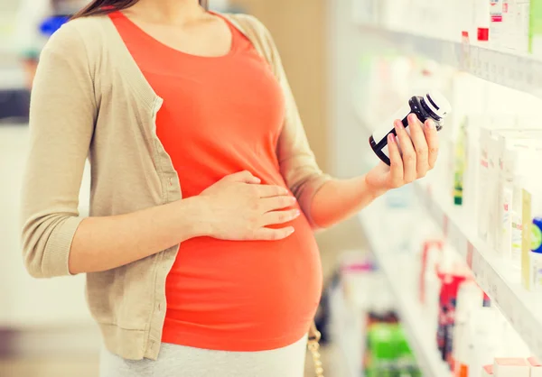 Беременная женщина с лекарствами в аптеке — стоковое фото