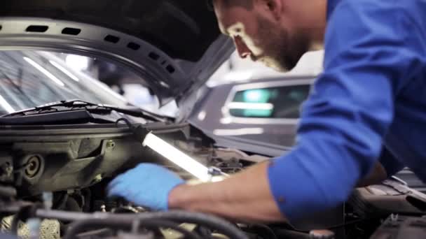 Mekaniker man med LAMP reparera bil på workshop 5 — Stockvideo