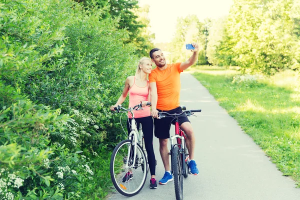 Para z rowerów i smartphone przy selfie — Zdjęcie stockowe