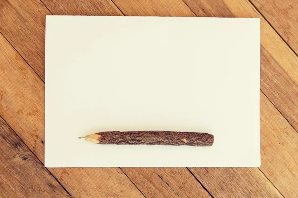Folha de papel em branco branco com caneta de madeira na mesa — Fotografia de Stock