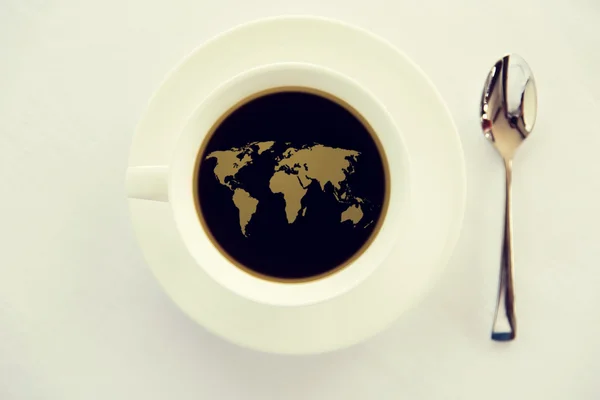 World map in cup of black coffee with spoon — Stock Photo, Image