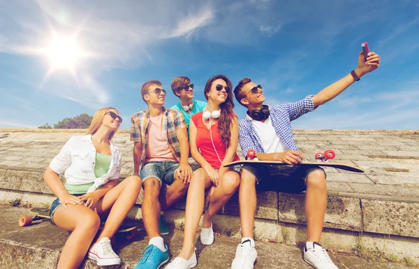 Група усміхнених друзів зі смартфоном на відкритому повітрі — стокове фото