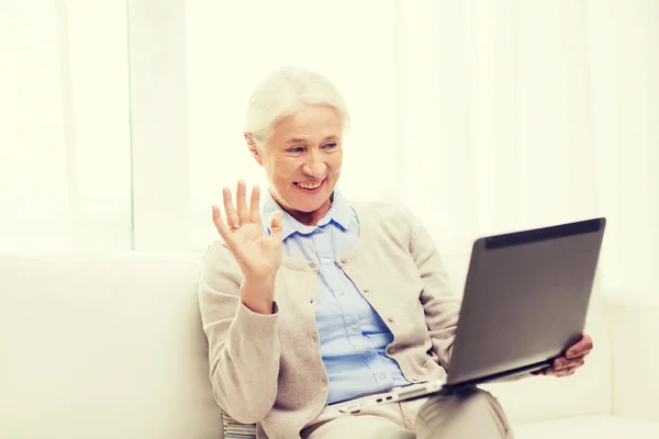 Donna anziana con computer portatile con video chat a casa — Foto Stock