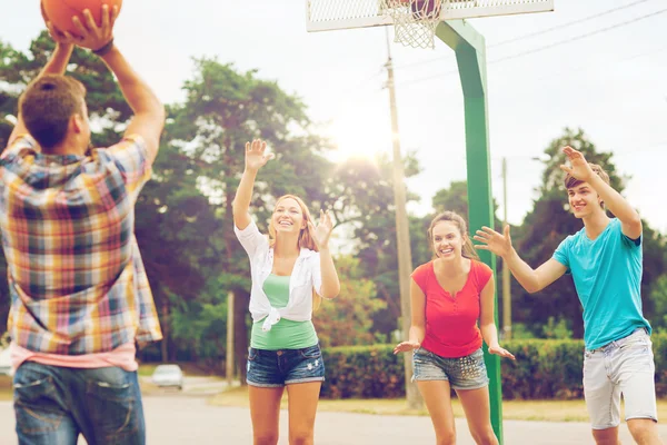 Skupina usměvavá teenagerů hrát basketbal — Stock fotografie