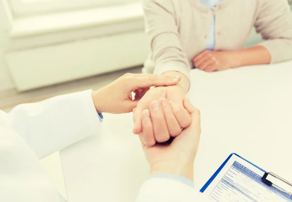 Doctor checking senior woman pulse at hospital — Stock Photo, Image