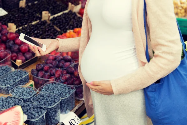 Mulher grávida com smartphone no mercado de rua — Fotografia de Stock