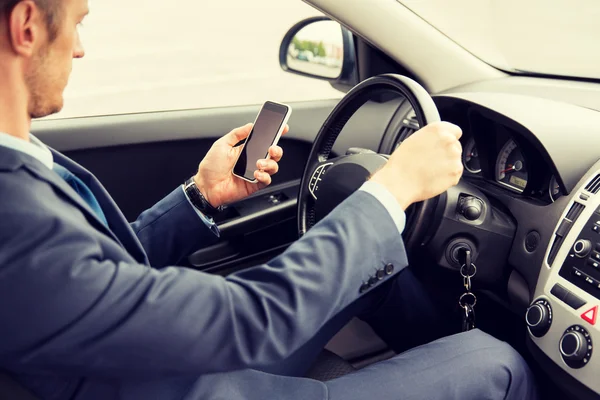 Närbild på mannen med smartphone som kör bil — Stockfoto