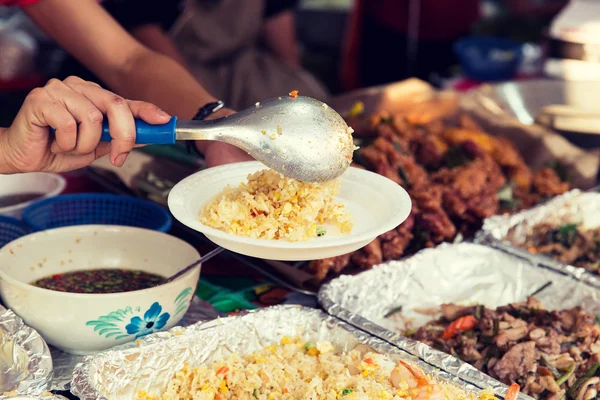 用铁锅在街边市场的手的特写 — 图库照片