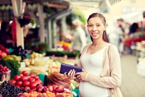 Mujer embarazada con billetera comprando alimentos en el mercado — Foto de Stock