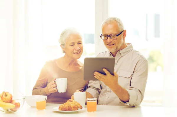 Felice coppia anziana con tablet pc a casa — Foto Stock