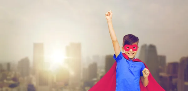 Jongen in rode superheld cape en masker met vuisten — Stockfoto