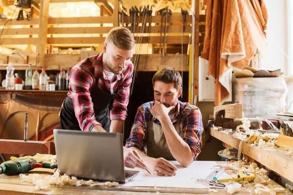 Falegnami con computer portatile e cianografia in officina — Foto Stock