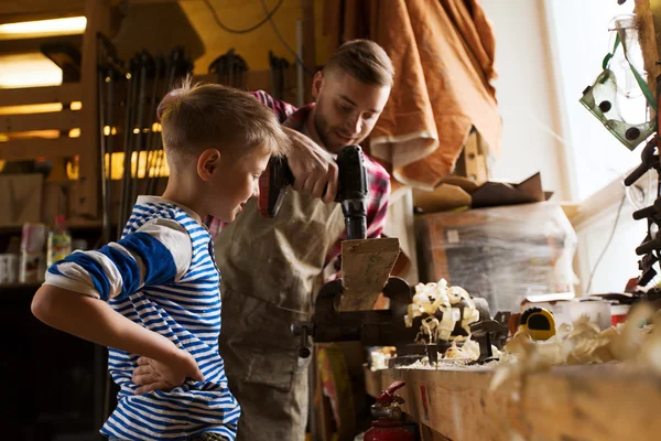 Father and son with drill working at workshop — Stock Photo, Image