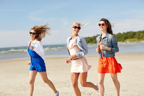 Groupe de femmes souriantes en lunettes de soleil sur la plage — Photo