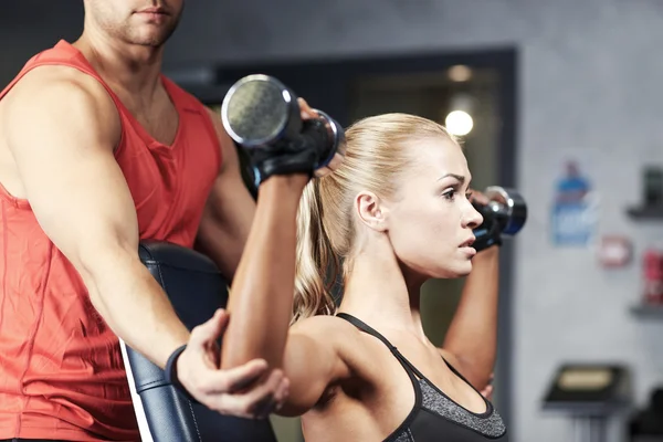 Man and woman with dumbbells in gym — Stock Photo, Image