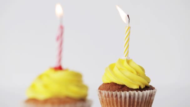 Кексы на день рождения с горящими свечами — стоковое видео