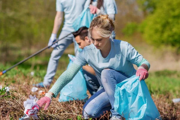 Voluntários com sacos de lixo área do parque de limpeza — Fotografia de Stock