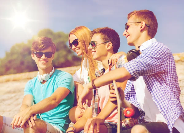 Group of smiling friends sitting on city street — Stock Photo, Image