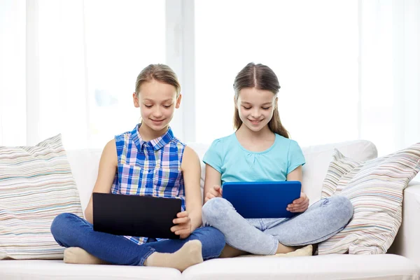 Ευτυχισμένα κορίτσια με tablet PC κάθεται στον καναπέ στο σπίτι — Φωτογραφία Αρχείου