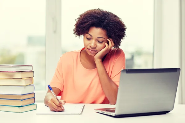 Mujer afroamericana aburrida haciendo la tarea en casa —  Fotos de Stock