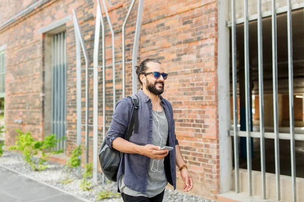 이어폰과 스마트폰 도시에 걷는 남자 — 스톡 사진