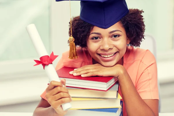 Happy african bachelor girl with books and diploma — Stock Photo, Image