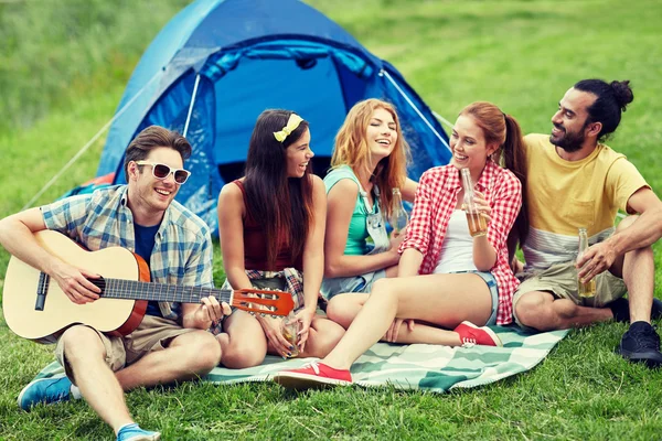 Amici felici con bevande e chitarra al campeggio — Foto Stock