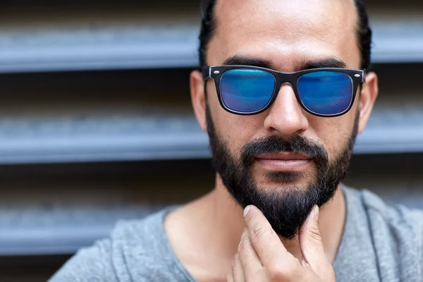 Uomo in occhiali da sole toccare la barba sulla strada della città — Foto Stock
