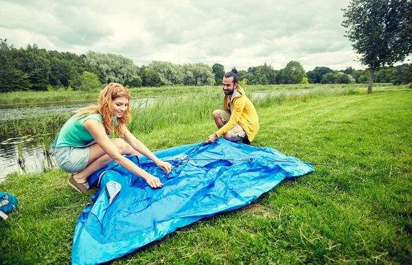 Casal feliz criação de tenda ao ar livre — Fotografia de Stock