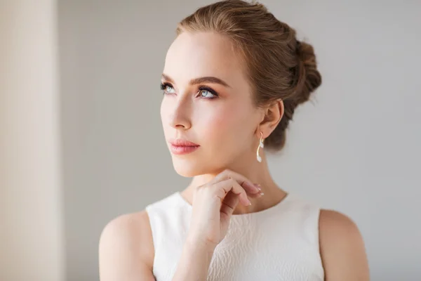 Mulher sorridente em vestido branco com jóias de diamante — Fotografia de Stock