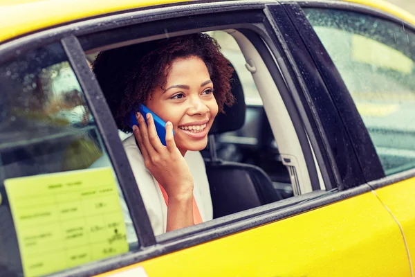 Happy african woman calling on smartphone in taxi — Stock Photo, Image