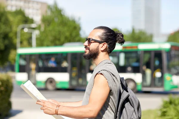 Utazótáska-val a backpack az ember, és a város térképe — Stock Fotó