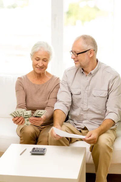 Seniorenpaar mit Geld und Taschenrechner zu Hause — Stockfoto