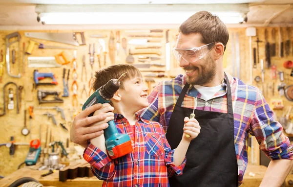 Pai e filho com broca trabalhando na oficina — Fotografia de Stock