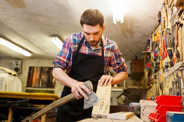 Carpenter with ax and board working at workshop — Stock Photo, Image